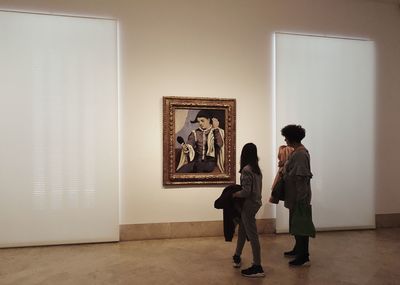 Friends standing against wall in museum