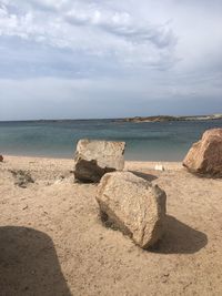 Rocks on beach against sky