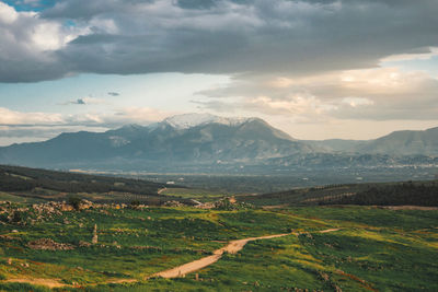 Scenic view of field and mountains against sky