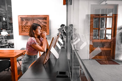 Woman standing by window at home