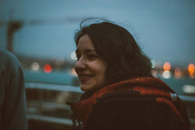 Side view of beautiful smiling woman wearing scarf