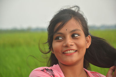 Portrait of smiling young woman on field