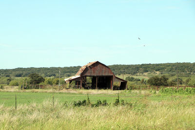 Built structure on grassy landscape against clear sky