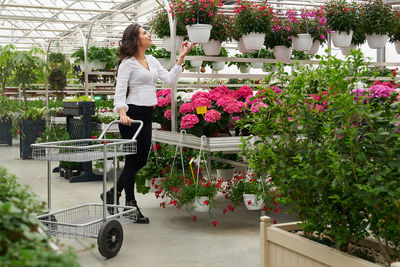 Woman standing by potted plants