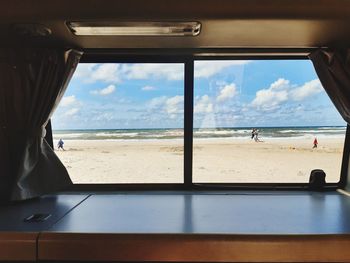 Scenic view of beach seen through window