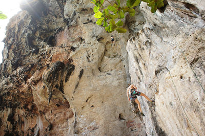 Low angle view of woman rock climbing