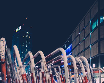 Barricades on street by modern buildings at night