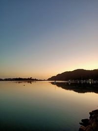 Scenic view of lake against clear sky during sunset