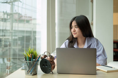 Smiling businesswoman looking away in office