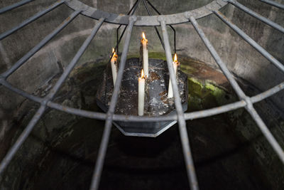 Close-up of illuminated lighting equipment dropping from well