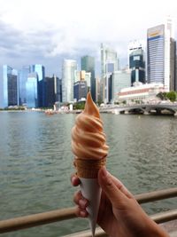 Person holding ice cream cone in city