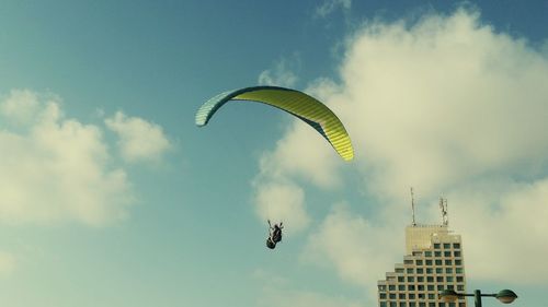 Low angle view of person paragliding against sky