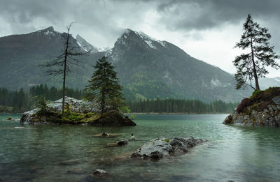 Scenic view of lake by mountains against sky