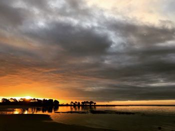 Scenic view of beach against dramatic sky