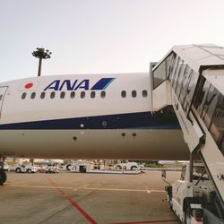 Airplane on airport runway against sky