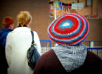 Rear view of person wearing rastacap against building