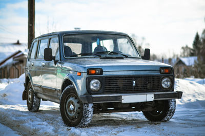 Vintage car on snow against sky