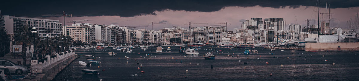 Panoramic view of buildings and sea in city against sky