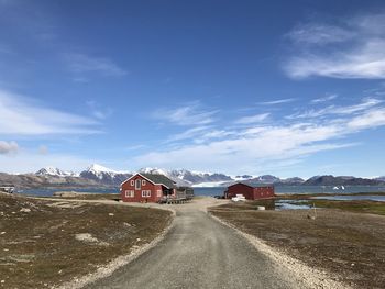 Road leading towards snowcapped mountains against sky