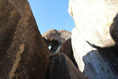 Rear view of man on rock against sky