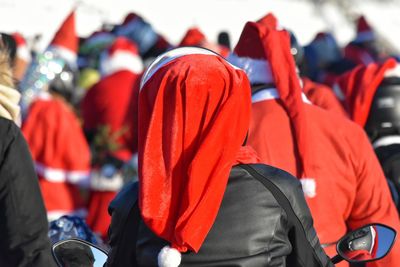 Rear view of people wearing santa hats in city during christmas