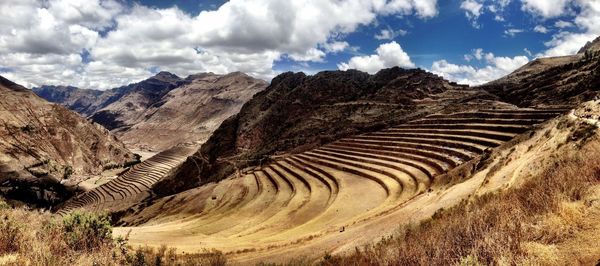 Inca ruins by mountains against sky