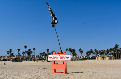 Lifeguard hut on beach against clear blue sky