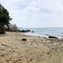 Scenic view of rocks on beach against sky