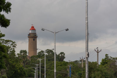 Low angle view of street light by building against sky