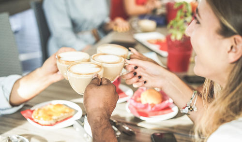 High angle view of happy friends toasting coffee