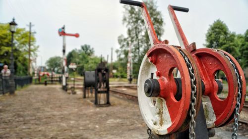 Close-up of red machinery on field against sky