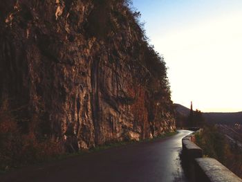 Road amidst trees against clear sky