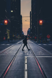 Rear view of man on road against illuminated city