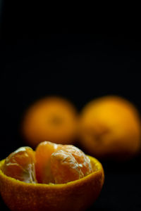 Close-up of oranges on table against black background