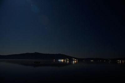 Scenic view of lake against sky at night