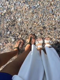 Low section of women standing at beach