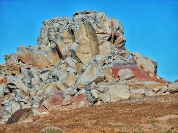 Low angle view of rock formation against blue sky