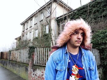 Thoughtful young man wearing warm clothing while looking away in winter
