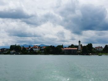 Houses by sea against sky