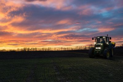 Scenic view of agricultural field against sky during sunset