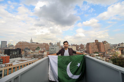 Portrait of man standing holding pakistani flag