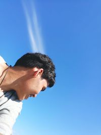 Low angle view of man looking away against sky