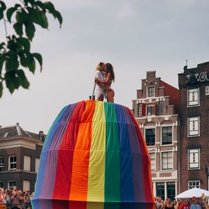 Statue of woman against sky in city