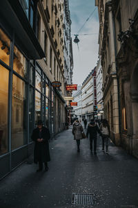 People walking on wet street in city