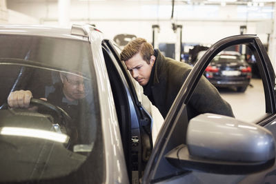 Male customer and mechanic at auto repair shop