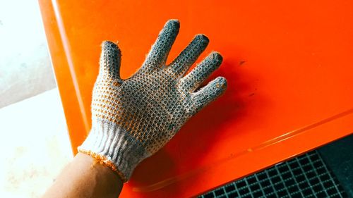 Close-up of hand holding orange leaf