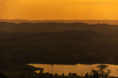 Scenic view of lake against orange sky
