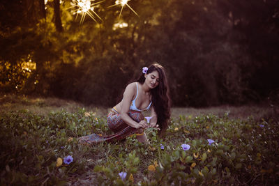 Young woman sitting on field