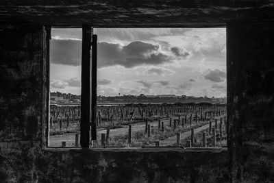 Built structure on landscape against cloudy sky