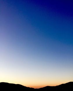 Silhouette landscape against clear blue sky